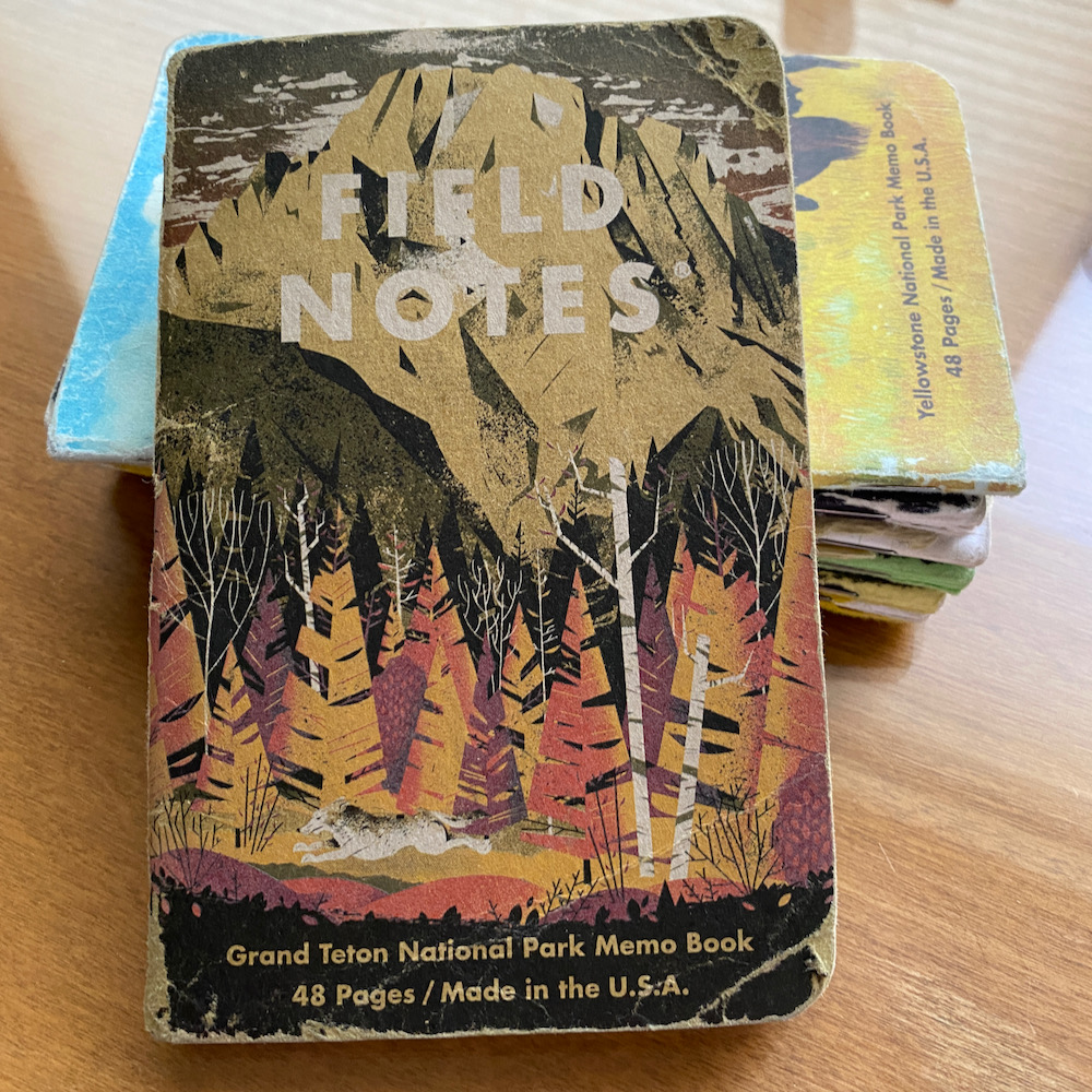 stack of my filled &lsquo;Field Notes&rsquo; notebooks with Grand Teton on top